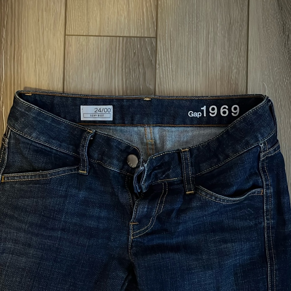 Dark wash low rise Gap 1969 bootcut jeans with flared leg.